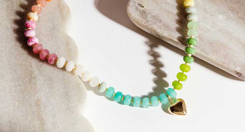 Women wearing blue bone bead necklace and black tank top