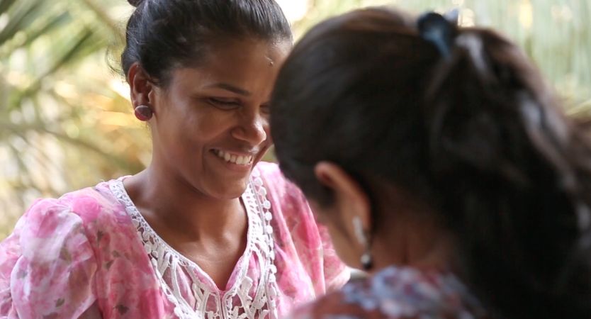 Two women talking and smiling.